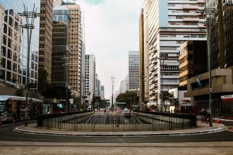 Vista urbana de São Paulo com trânsito intenso e arranha-céus modernos.